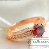 model inel de logodna cu cristal rotund de culoare rosie intens si cristale incolore lateral